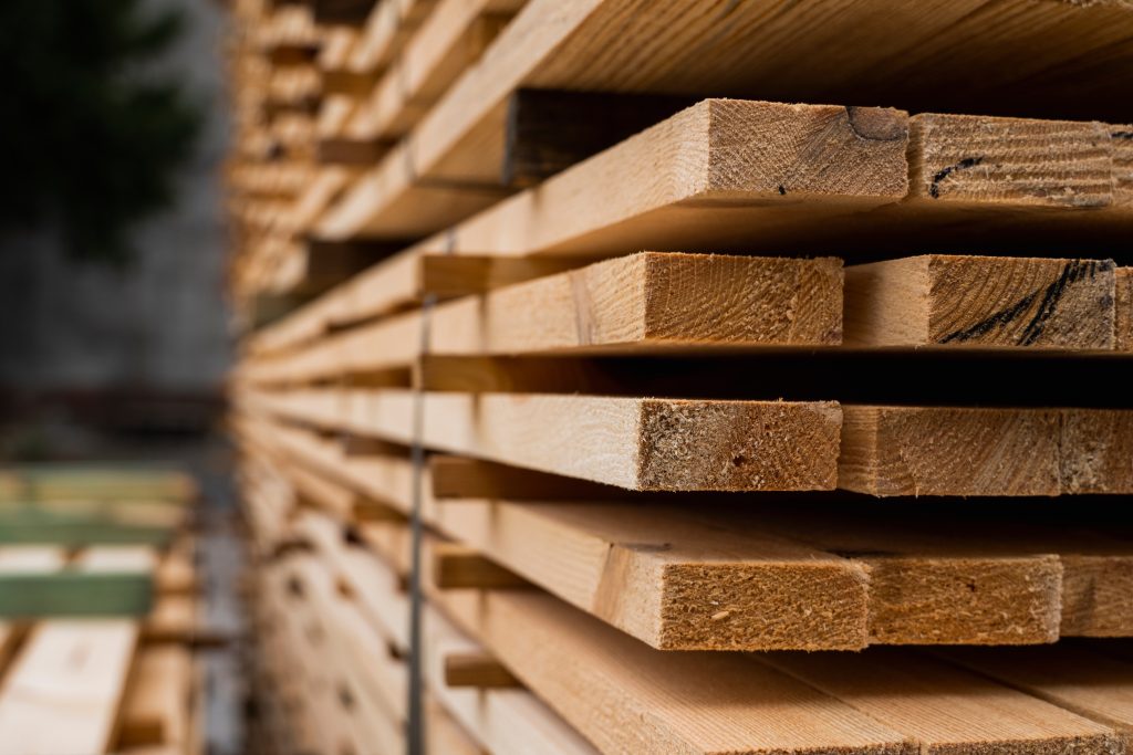 Piles of wooden planks at a sawmill waiting to be crafted into wooden windows
