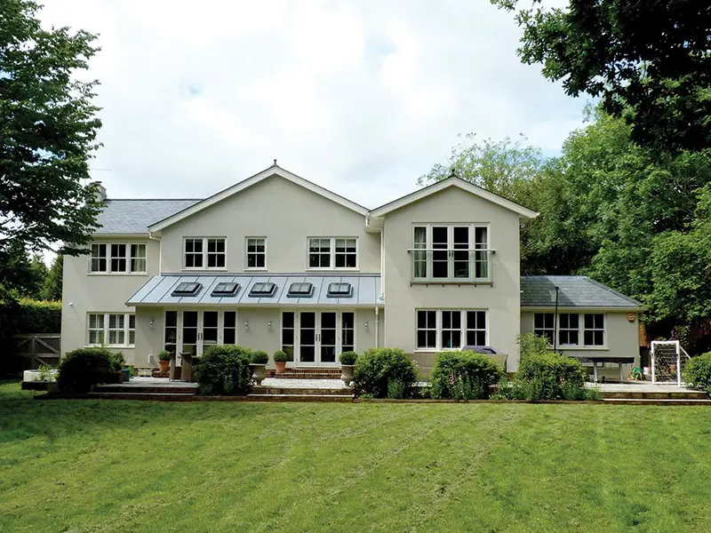 Garden view of large house with white French doors
