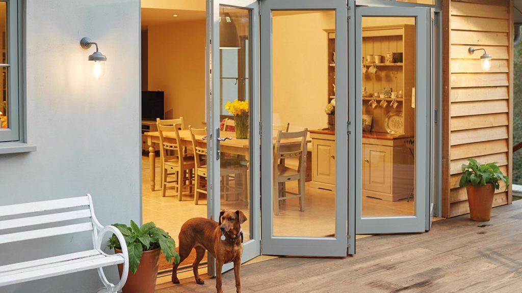 Grey bifold doors with brown dog standing in front