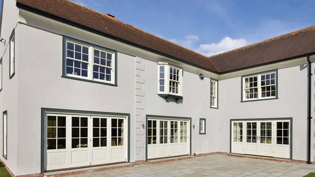 Grey house with white sliding sash windows and bifold doors