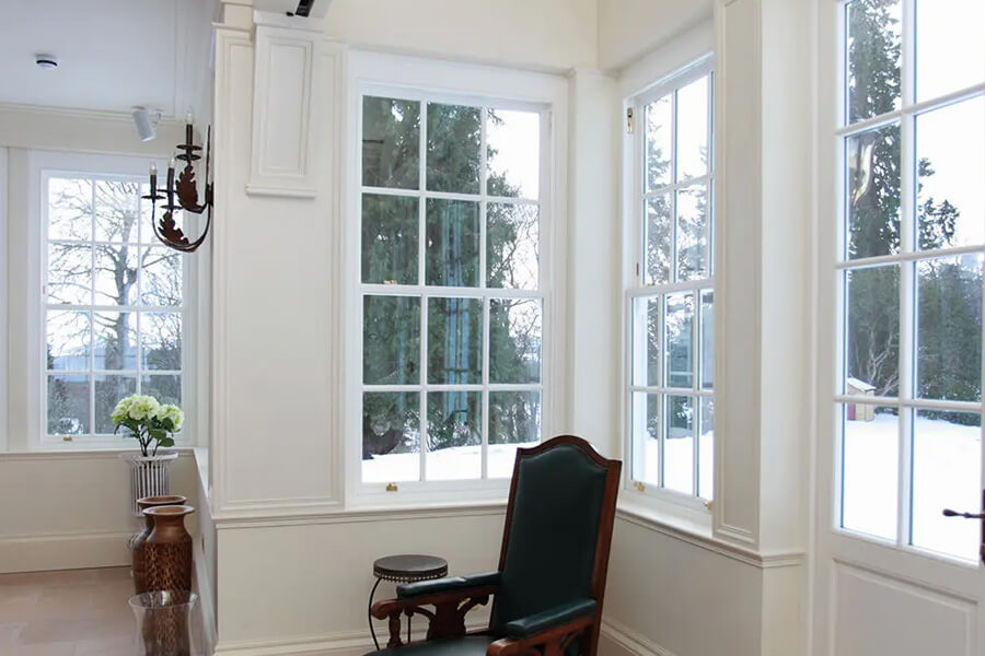 White sliding sash windows looking out to a snowy garden