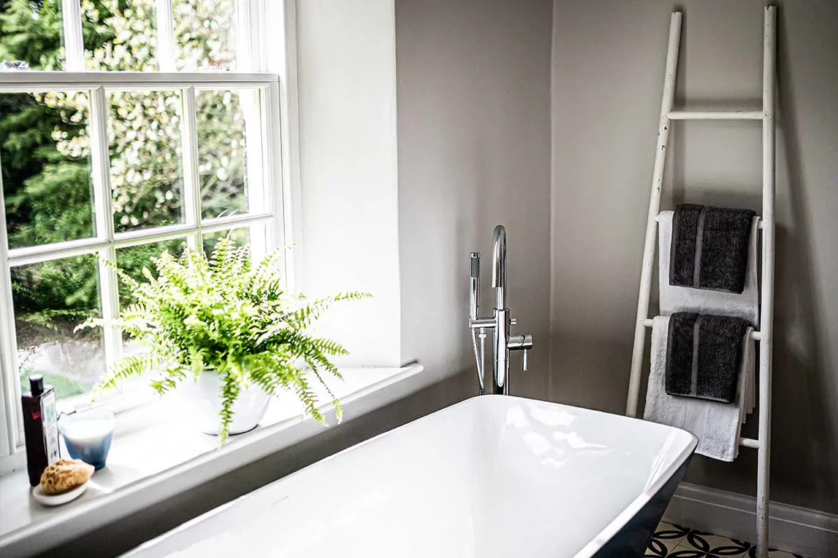 Close up of a bath next to a sliding sash window