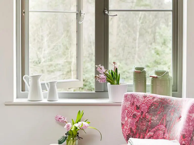 Opened window next to pink arm chair