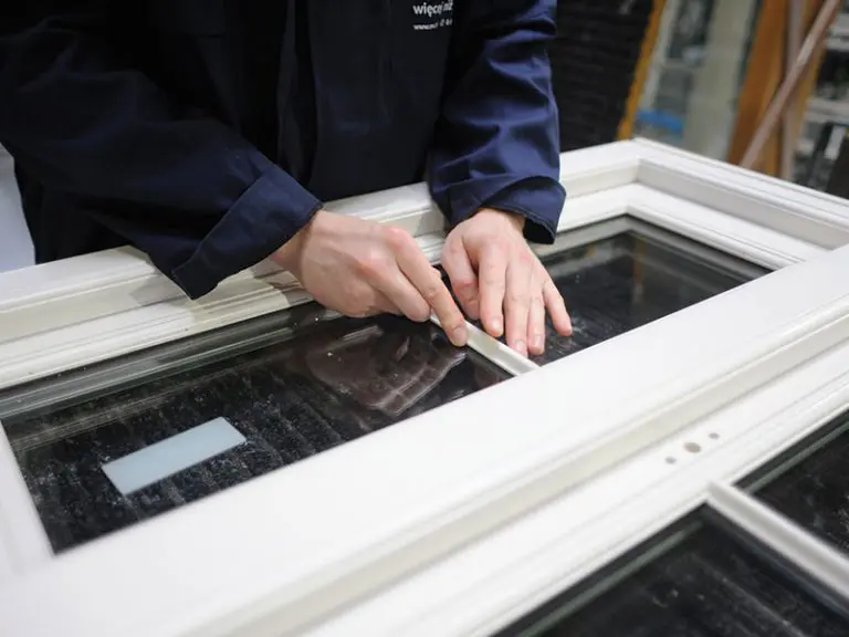Worker putting together a window at a factory