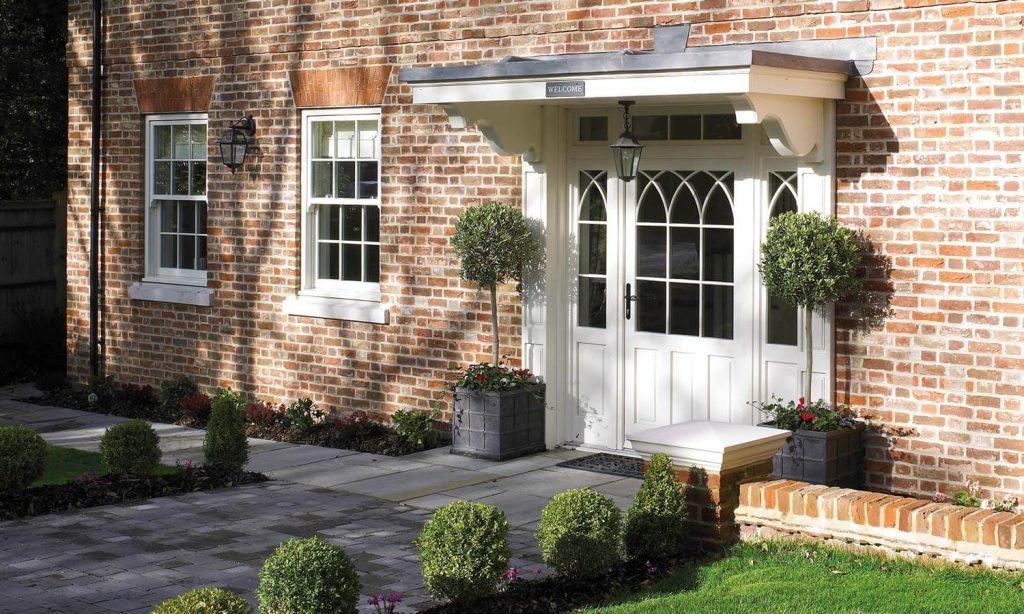 A charming brick house, adorned with a pristine white door and matching window.