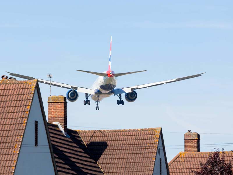 British Airlines Plane flying at very low altitude above houses while landing in London