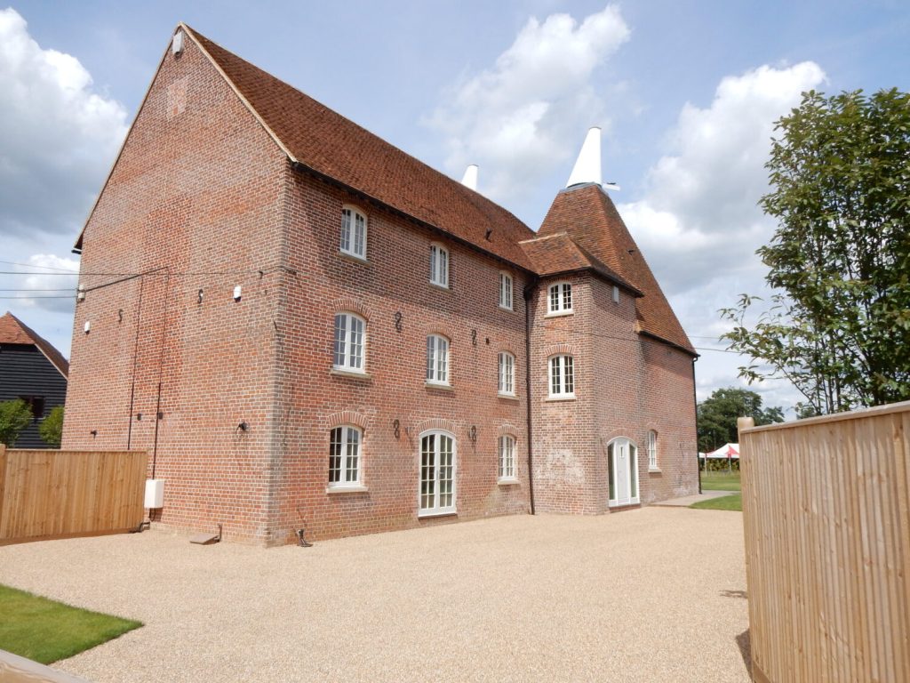 A substantial brick house, complemented by a wooden fence positioned directly before it.