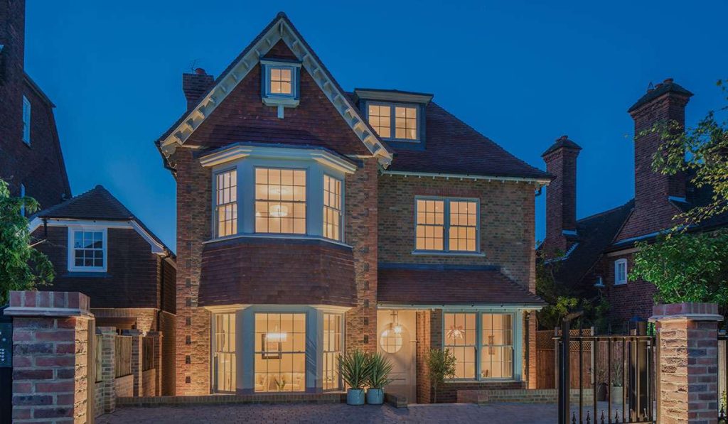 external evening shot of a cheshire house with lights on with timber windows
